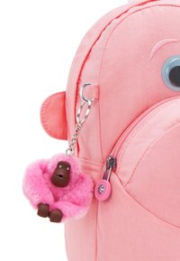 Zaino in tessuto rosa con design arrotondato. Include un portachiavi a forma di scimmia rosa in peluche e un accento oculare. Comporta una chiusura a zip.