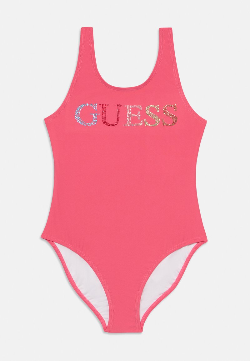 Fato de banho rosa em uma peça só, com decote arredondado e alças largas, apresentando a palavra "GUESS" em strass multicoloridos na parte da frente.