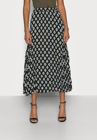 Maxikjol med svart, vit och teal diamantmönster, veckad design och elastisk midja. Tillsammans med svarta remsandaler.