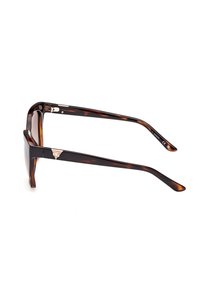 Lunettes de soleil en écaille de tortue avec des verres rectangulaires, monture brillante marron foncé, accent en métal près des charnières et branches élégantes.