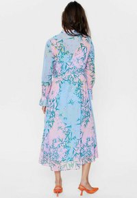 Rochie lungă, din materiale fine, cu mâneci lungi, în nuanțe pastel de albastru și roz, cu modele florale și de bambus; talie strânsă, tiv fluid, asortată cu pantofi cu toc portocalii.