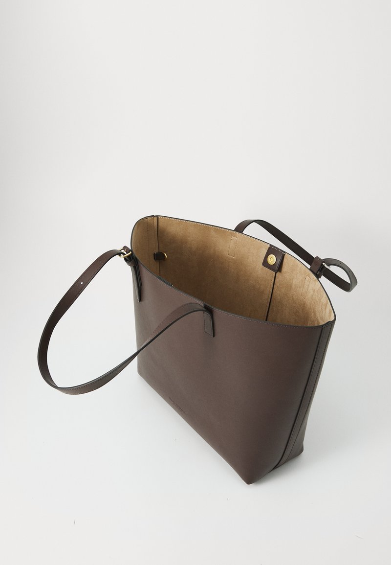 Braune Ledertasche mit weiter Öffnung oben, glatter Textur, verstellbarem Trageriemen und beigem Innenfutter mit dezenten Stichelementen.