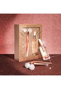 Klare Quarz 3D Lift- und Sculpt-Set in einer goldenen Box mit roségoldenen Akzenten, das einen Kristallroller und Essensfläschchen mit Tropfern enthält.