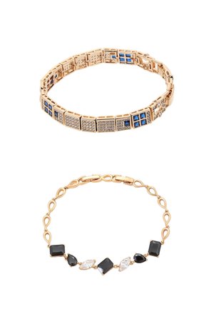 Goldene Armbänder mit blauen und klaren quadratischen Edelsteinen auf dem oberen Armband sowie schwarzen und klaren tropfen- und quadratförmigen Edelsteinen auf dem unteren Armband.