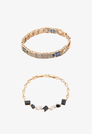 Brățări din aur cu pietre prețioase pătrate albastre și transparente pe brățara superioară, și pietre prețioase negre, transparente, în formă de lacrimă și pătrate pe cea de jos.