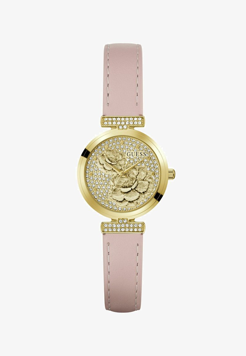 Montre Guess ton or avec cadran orné de cristaux et de motifs floraux, bracelet en cuir rose et accents en cristal sur les anses.