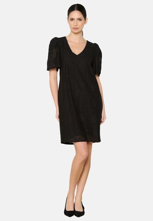 Robe noire avec des manches courtes bouffantes et un col en V, ornée de motifs en dentelle délicats et d'une coupe légèrement ample, se terminant au-dessus du genou.
