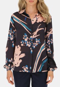Koszula z długim rękawem, zapinana na guziki, w ciemnym granacie z kolorowymi, kwiatowymi i abstrakcyjnymi wzorami w różowym i niebieskim. Miękka, teksturowana tkanina z dopasowanymi mankietami.