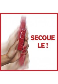 Produit rectangulaire rouge tenu dans une main, présentant une texture striée et un texte blanc en gras indiquant "SECOUE LE !" sur un fond uni.