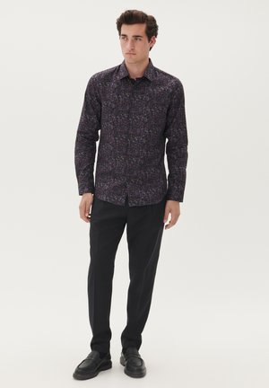 Herren dunkelviolette Langarmshirt mit Laubdruck. Knöpfe auf der Vorderseite, schlanke Passform. Kombiniert mit schwarzen Hosen und Slippern.