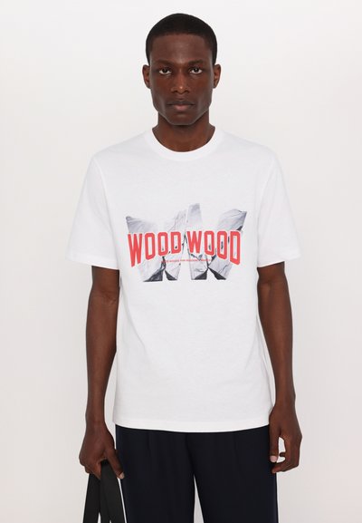 Balta medvilninė marškinė su dideliu raudonai ir juodai spausdintu grafiniu užrašu "WOOD WOOD" priekyje. Trumpi rankovės ir apvalus iškirpimas.