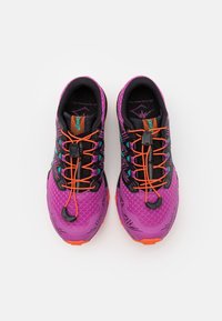 Zapatillas de deporte moradas con acentos negros y un sistema de cordones naranja. Superficie texturizada con un diseño estampado en los laterales. Suelas de goma.