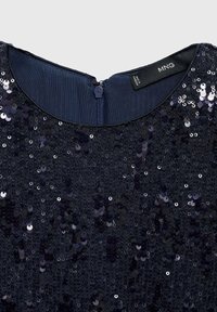 Encolure de robe bleu foncé avec une fermeture éclair dissimulée et des sequins brillants cousus en densité, montrant l'étiquette de la marque MNG à l'intérieur du col.
