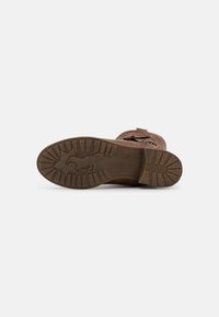 Botte marron avec tige en cuir texturé, semelle en caoutchouc présentant un motif de traction et un design de cheval gravé. Couture détaillée sur la tige.