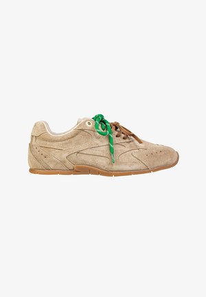 Sneaker in suede color tan con punta arrotondata e suola in gomma. Presenta lacci verdi e marroni, texture liscia e dettagli perforati sui lati.