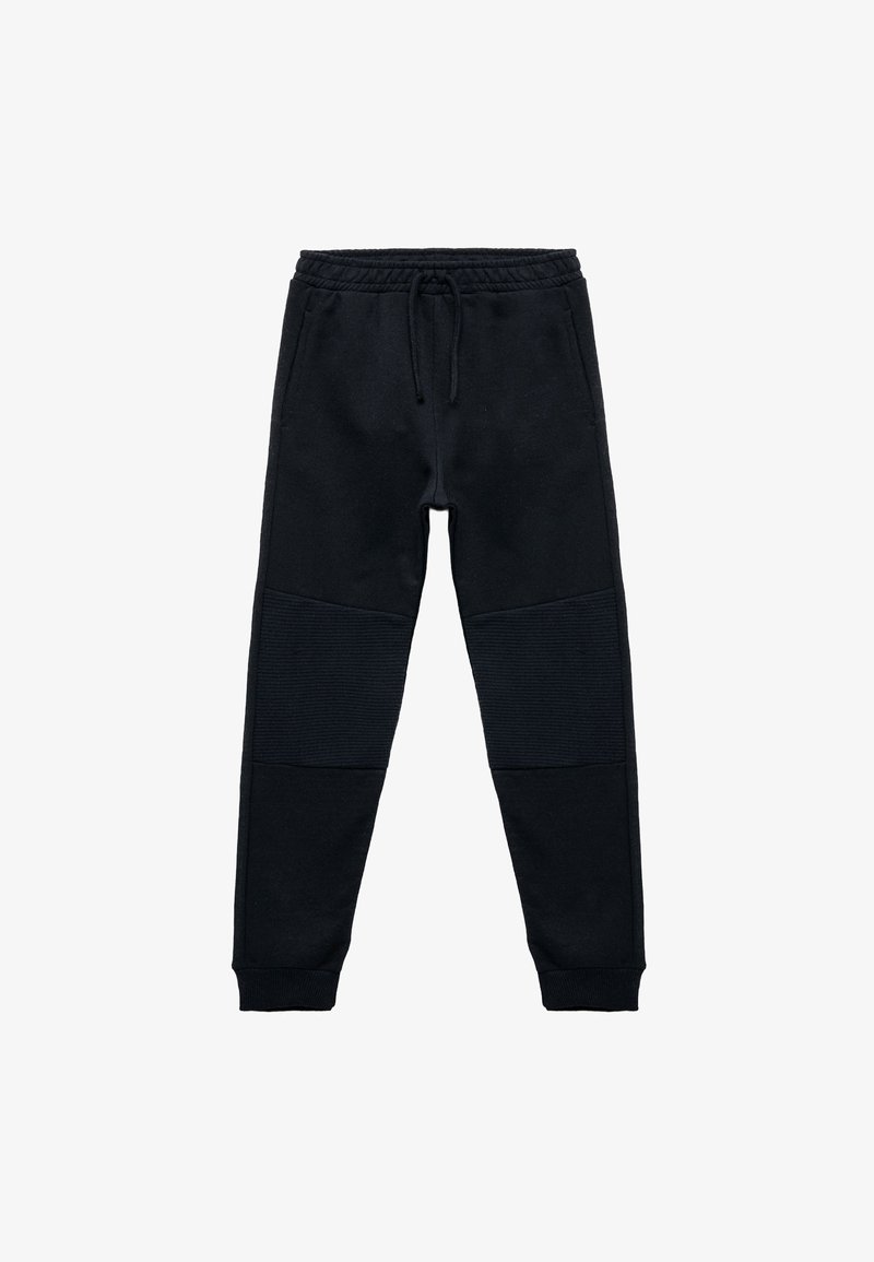 Sorte joggebukser lavet af blødt stof, med snøre i taljen, ribbede knædetaljer og tætsiddende ankelsluttere for en god pasform.