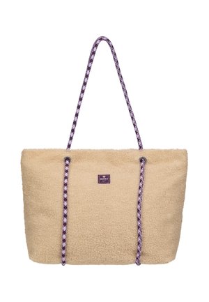 Beige flauschige Tragetasche mit langen lila-weißen gemusterten Seilgriffen und einem kleinen mittig angebrachten Markenlabel vorne.