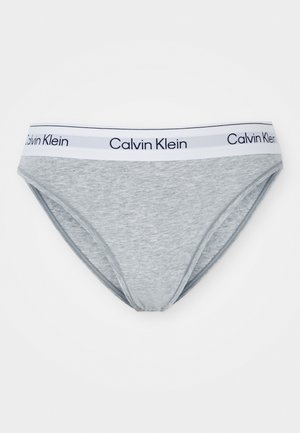 Grå bomullsbikini-truser med hvit livlinje som har blå "Calvin Klein"-logo. Glatt tekstur og tradisjonell fasong.