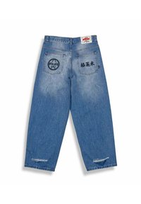 Pantalones de mezclilla azul con un corte relajado, que cuentan con dos bolsillos traseros. Un bolsillo tiene un diseño circular y el otro tiene bordado negro.