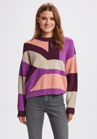 Maglione lavorato a maglia con blocchi di colore geometrici in viola, rosa e beige, con una texture a coste e un collo rotondo.