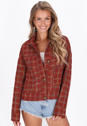 Chaqueta de tweed roja con un patrón de cuadros, botones metálicos y cuello. Presenta una tela texturizada y cálida con acentos multicolores.