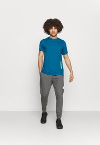Nike Performance DRY TAPER - Pantalones deportivos - charcoal heather/white