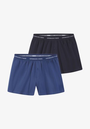 Vīriešu bokseršorti tumši zilā un karaliskā zilā krāsā, ar mīkstu audumu, elastīgu jostu ar "Copenhagen Studios" zīmolu un pogu aizdari.