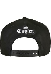 Must mustriga, millel on reguleeritav nööbikinnitus. Seljaosas on valge broderitud brändi nimi "Cayler" ja kroonilogo.