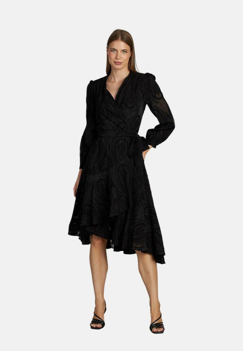 Schwarzes Wickelkleid aus strukturiertem Stoff, mit langen Ärmeln und asymmetrischem Saum. Es hat eine taillierte Taille und einen fließenden Rock.