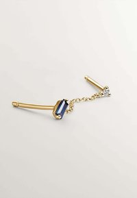 Accessorio para el cabello en tono dorado que presenta una piedra rectangular azul y un pequeño cristal claro, conectados por una delicada cadena.