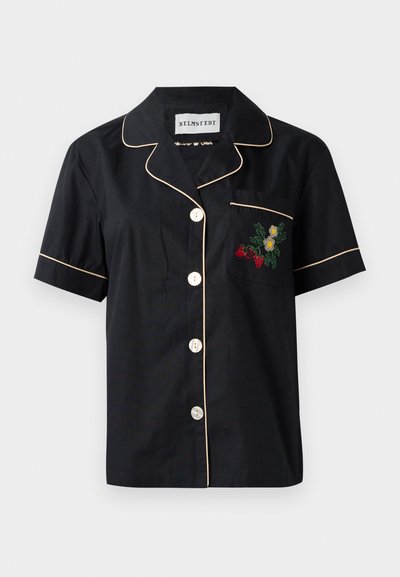 Μαύρο κοντομάνικο πουκάμισο με αντίθεση μπεζ διακοσμήσεις, πεντακάθαρο κούμπωμα μπροστά και αριστερή τσέπη στο στήθος με κεντημένα λουλούδια.