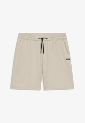 Beige athletic shorts made of breathable fabric, featuring an elastic waistband with a drawstring, and side pockets. Subtle perforated pattern.
