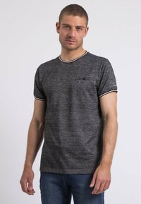 T-shirt à manches courtes noir et blanc rayé, avec un col rond et une coupe ajustée, arborant une texture subtile et un petit logo sur la poitrine.