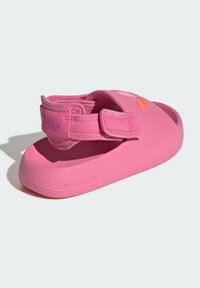 Rosa Sandale aus flexiblem Material mit einem sicheren Klettverschluss, einer abgerundeten Zehe und einer strukturierten Sohle für besseren Halt. Adidas-Logo sichtbar.