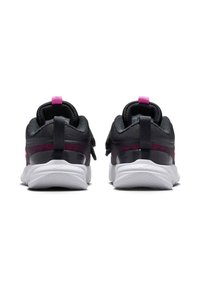 Zapatillas deportivas negras con acentos rosas, con una parte superior texturizada, materiales de tela dual y una suela blanca gruesa para mayor amortiguación.