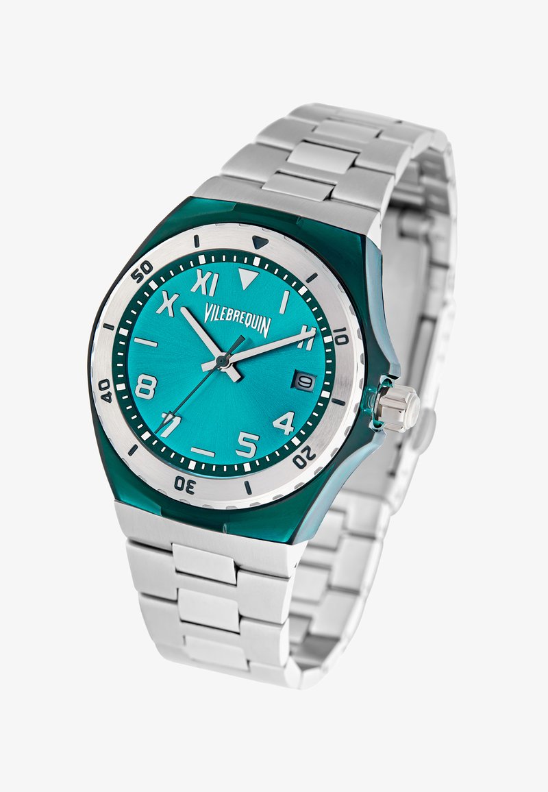 Vilebrequin pulksteņu ar zaļganu dialu, sudraba nerūsējošā tērauda siksniņu, gaismojošām rokām un uzkrītošiem stundu rādītājiem, kurā ir datuma logs pulksteņa 3 stundās.