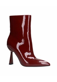 Bottine en cuir verni rouge avec un bout pointu et un talon aiguille. La finition brillante met en valeur le design épuré et la silhouette moderne.
