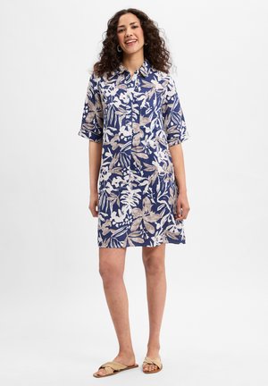 Blaues Knopfhemdkleid mit floralen Mustern in Weiß und Beige, kurze Ärmel, entworfen für eine lockere Passform, bis über das Knie reichend. Weicher Stoff.