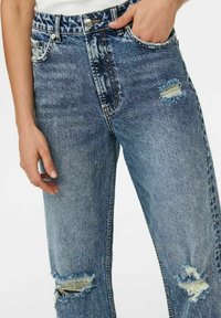 Jeans azzurri chiari con effetto usurato, caratterizzati da buchi sfilacciati sulle ginocchia, design tradizionale a cinque tasche e chiusura con bottoni classica.