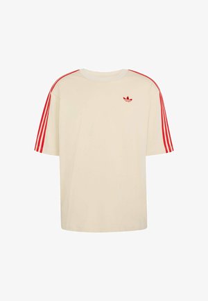 Krémově zbarvená košile s krátkým rukávem, s červenými třemi pruhy na rukávech a malým červeným logem Adidas na levé straně hrudi.