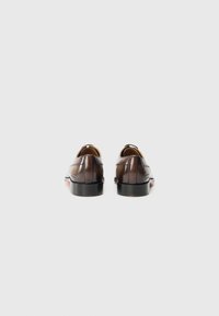 Scarpe da uomo in pelle marrone con finitura liscia, punta tonda e cuciture decorative sui lati. Tacco nero, design minimalista.