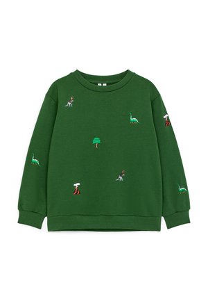 Zielona bluza z długim rękawem z wyszywanymi dinozaurami, drzewami i wulkanami rozsianymi na przodzie i rękawach.