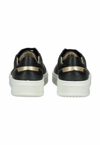 Sneaker in pelle nera con suola in gomma bianca, dotate di una striscia d'accento dorata al tallone e una morbida fodera beige. Vista posteriore.