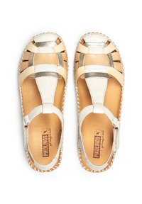 Sandalias de cuero beige y blanco con detalles dorados, diseño de punta abierta, textura trenzada y bordes cosidos. Cuenta con una correa para el tobillo que brinda soporte.