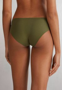 Olivgrüne Hipster-Unterwäsche aus glattem Stoff mit nahtlosem Design, das einen mittelhohen Sitz und minimale Abdeckung hinten bietet.