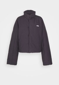 Veste matelassée noire avec col haut, manches longues, boutons à l'avant et petit logo blanc "032c" sur la poitrine gauche.