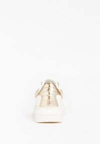 Weißer Sneaker mit einer strukturierten goldenen Krokodilprägung an der Ferse, gepolsterter Sohle und schlichtem Design. Keine sichtbaren Schnürsenkel oder zusätzlichen Akzente.