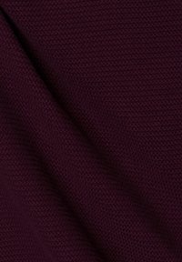 Dunkelburgunderfarbener, gestrickter Stoff mit strukturierter Oberfläche, der ein enges Webmuster aufweist. Weich, flexibel, geeignet für verschiedene textile Anwendungen.