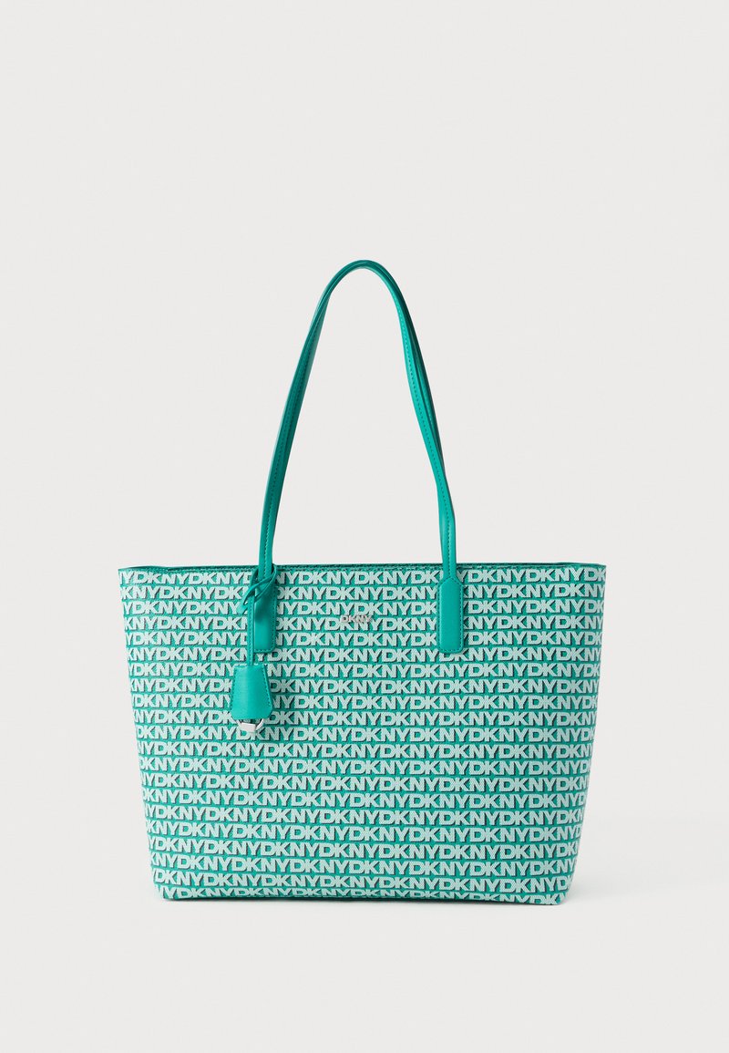 Turquoise színű táska, amelyen ismétlődő fekete márkajelzés található. Sima felületű, dupla felső fogantyúval és levehető címketartóval.