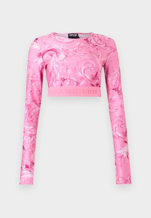 Ροζ crop top με μακριά μανίκια, διακοσμημένο με σχέδιο βαρύτονου και τη φράση "Versace Jeans Couture" ανάγλυφη στη ζώνη μέσης.